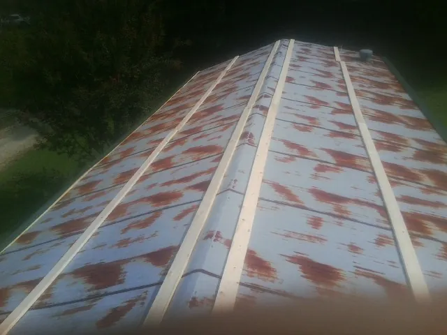 Rusted metal roof panels with new wood purlins before replacement — Storm Damage Roof Repair in Doyle by Roofing Brothers