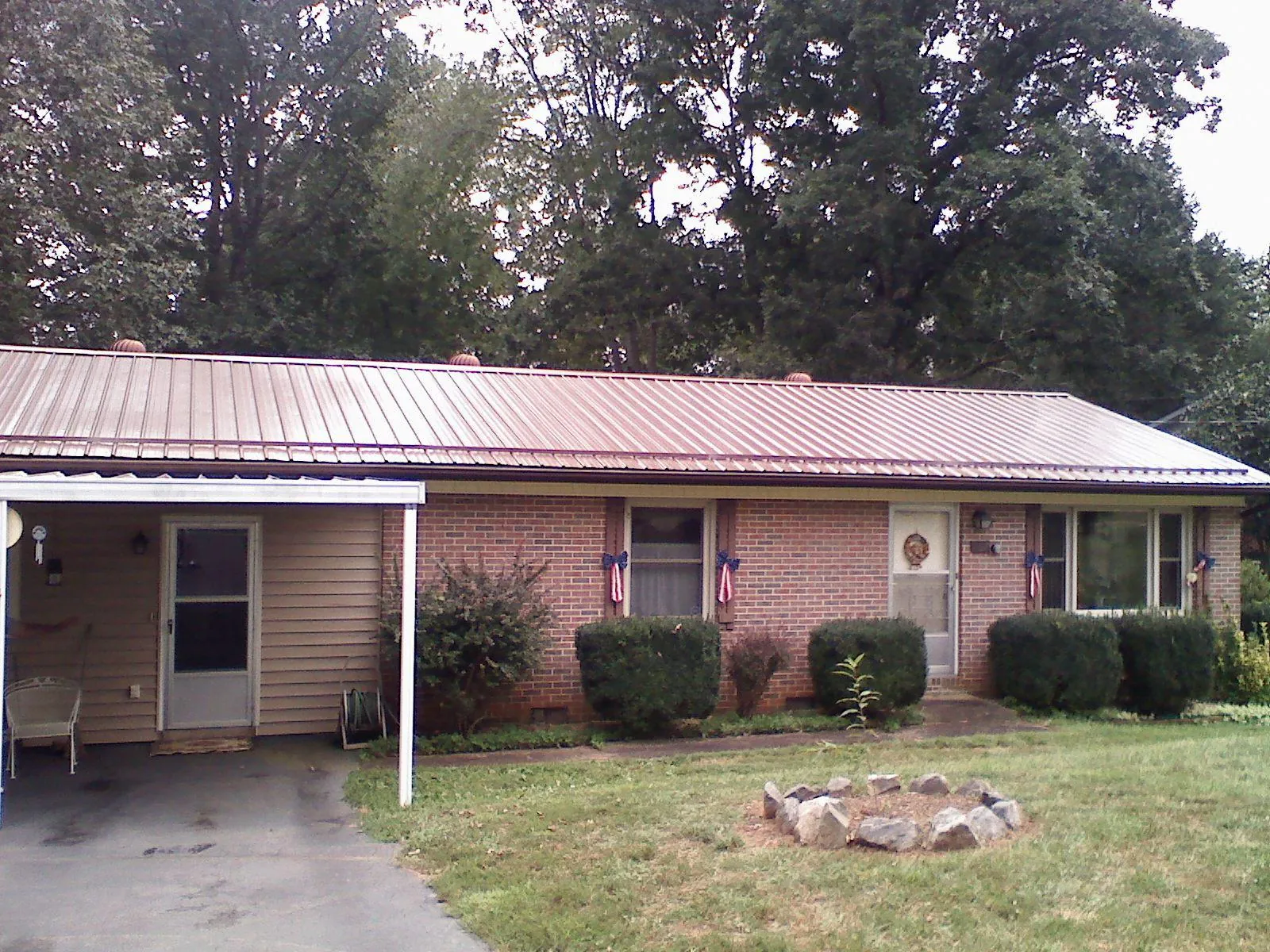 Bronze metal roof and carport on a brick ranch home — Roof Repair work by our crew in Doyle